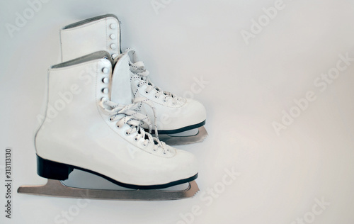 white ice skates for figure skating on a white background, copy space