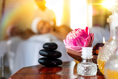 Massage Stones, Pink lotus flowers, herbal ball, spa oil With Towels And Candles. Massage, Spa, Health & Wellness Retreats concept.