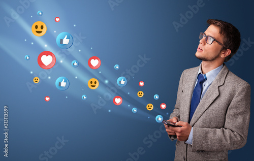 Young person using smartphone with flying social media icons around
