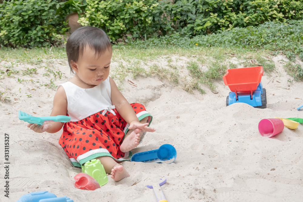 Asian baby girl playing sand outdoor. Kid building sand castle. Asian baby girl playing sand outdoor. Kid building sand castle.