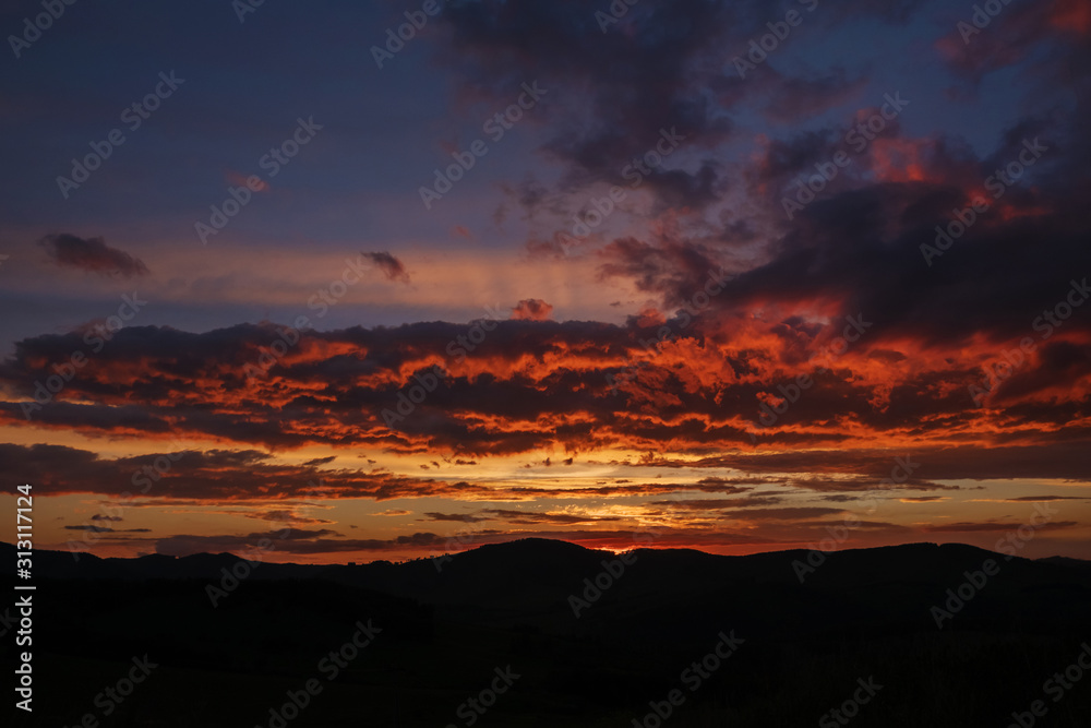 Red light after sunset, deep blue color of the sky. The rays of the setting sun illuminate the clouds below. Red light after sunset, deep blue color of the sky. The rays of the setting sun illuminate the clouds below.
