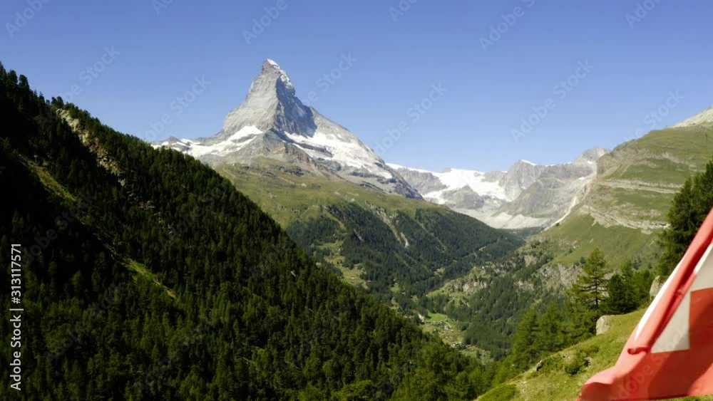 Swiss flag on mountain top in front of Matterhorn