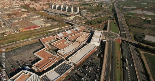 Aerial view over commercial area in the suburbs of Barcelona, Spain, showing distinct urban zones such as malls, industrial sites, suburban residential buildings, and bypass highway