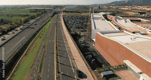 Aerial view over commercial area in the suburbs of Barcelona, Spain, showing a large mall, parking lots and highway roads nearby