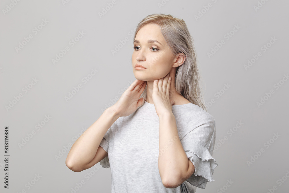 Female checking thyroid gland by herself. Close up of woman in white t- shirt touching neck with red spot. Thyroid disorder includes goiter, hyperthyroid, hypothyroid, tumor or cancer Health care. Female checking thyroid gland by herself. Close up of woman in white t- shirt touching neck with red spot. Thyroid disorder includes goiter, hyperthyroid, hypothyroid, tumor or cancer Health care.