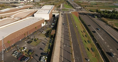 Aerial view over commercial area in the suburbs of Barcelona, Spain, showing a large mall, parking lots and highway roads nearby