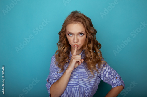 Blond female with shh sign isolated in the white studio