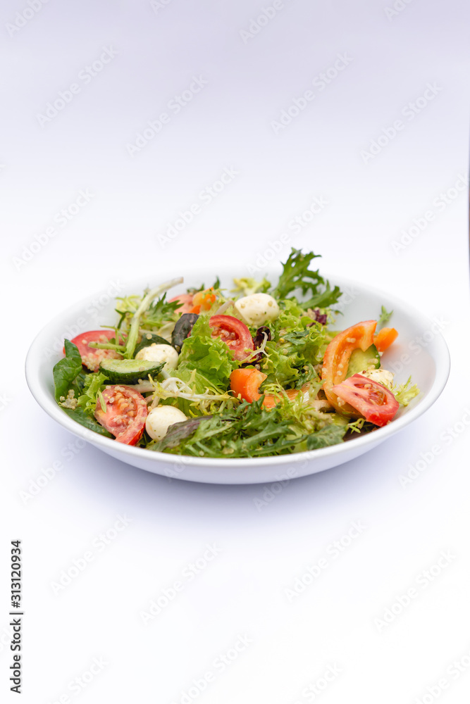 white deep plates with fresh salad ingredients mixed with sauce placed on isolated white background. A place for a menu, banner or advertisement