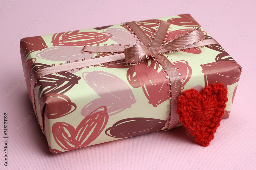 Packed gift and heart close-up. Valentine's day, love and wedding concept Packed gift and heart close-up. Valentine's day, love and wedding concept
