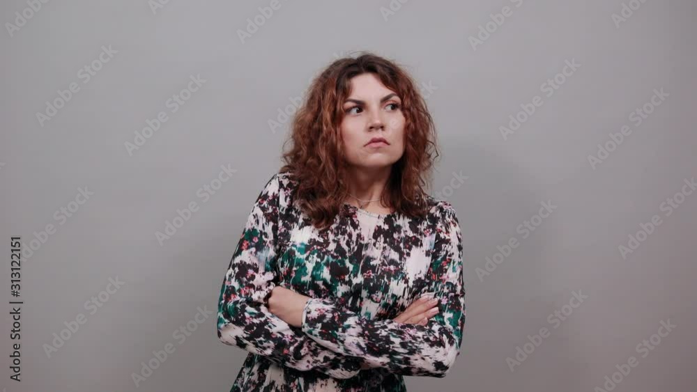 Scared charming young lady keeping hands crossed, bitting nails, having nice ring over isolated gray background in fashion shirt. People emotions. Lifestyle concept Scared charming young lady keeping hands crossed, bitting nails, having nice ring over isolated gray background in fashion shirt. People emotions. Lifestyle concept