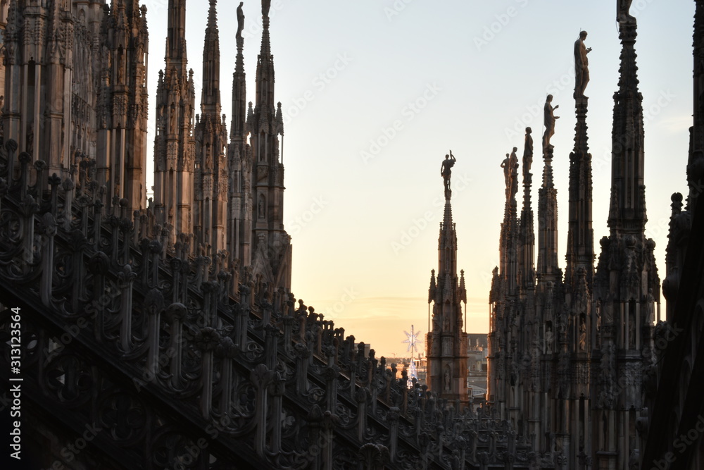 Pillars of milan cathedral and sunset in background