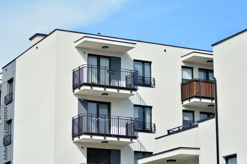 Contemporary residential building exterior in the daylight. Modern apartment buildings on a sunny day with a blue sky. Facade of a modern apartment building