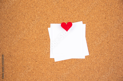 one red heart note paper on cork board