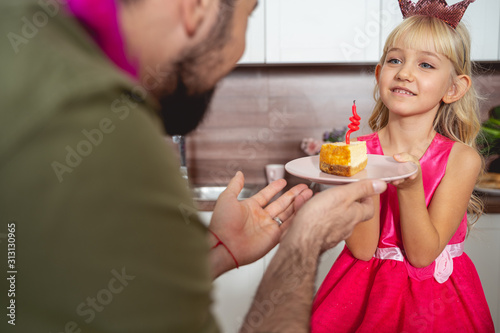 Adorable little girl celebrating birthday with dad at home
