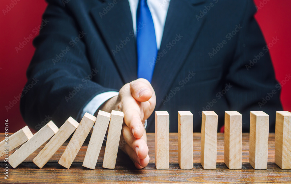Fotografie Businessman stops domino falling
