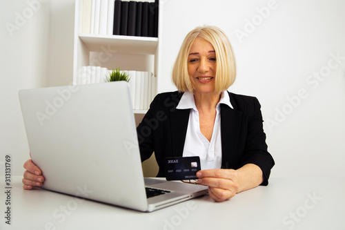 Office woman using black credit card on the computer