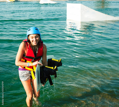 young smiling girl on wake board in water, happy lifestyle people on vacations photo