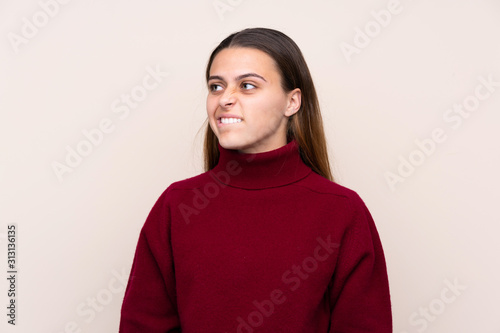 Teenager girl over isolated background having doubts and with confuse face expression © luismolinero