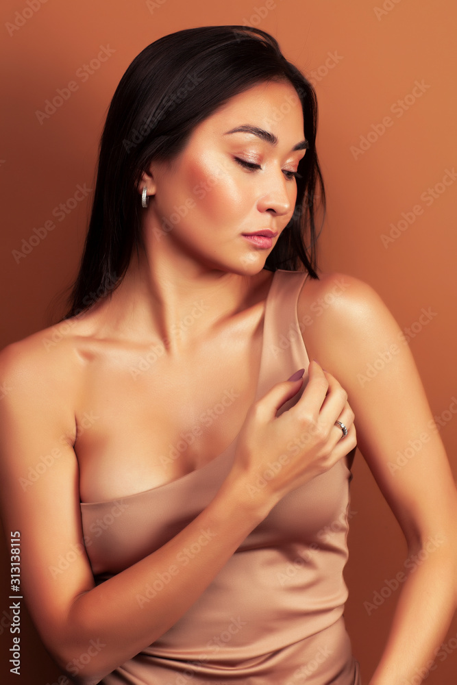 young pretty asian woman cheerful smiling posing on warm brown background, lifestyle people concept young pretty asian woman cheerful smiling posing on warm brown background, lifestyle people concept