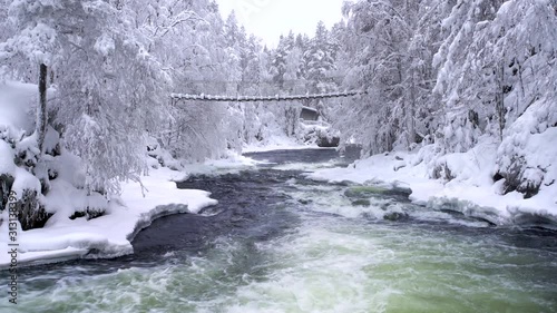 suspension bridge over a river rapids at winter
