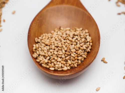 Toasted sesame seed on wood spoon 