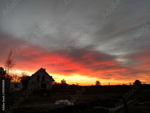 Red orange sunset over construction site in Poland.