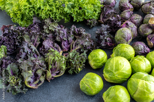 Variety of cabbage on dark board, high angle view