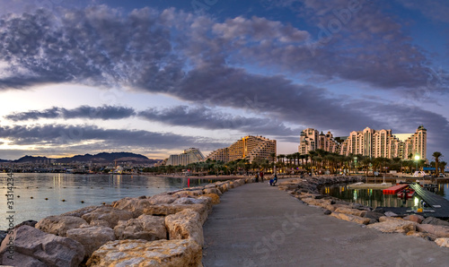 Night panoramic view from public walking pier on central beach and promenade of Eilat - famous tourist resort and recreational city in Israel