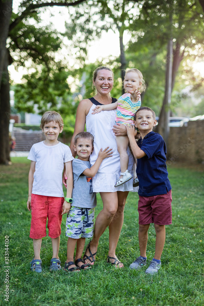 Young woman with toddler girl and three young boys in summer park Young woman with toddler girl and three young boys in summer park