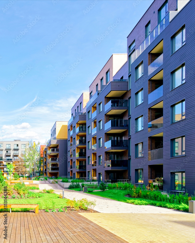 Apartment in residential building exterior. Housing structure at blue modern house of Europe. Rental home in city district on summer. Wall and glass high architecture for business property investment.