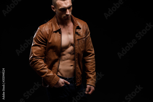 Young handsome man, leather jacked on naked torso, emotional posing, lifestyle people concept © kiy_lg