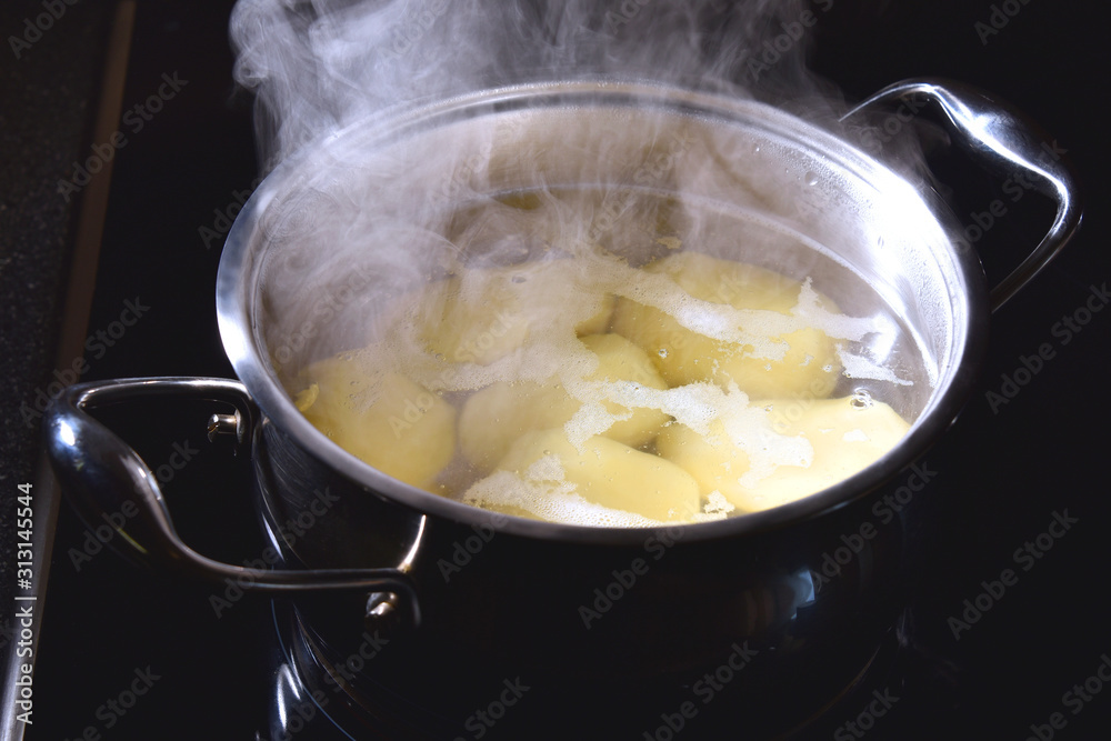 Potatoes boil in a saucepan on the stove Potatoes boil in a saucepan on the stove