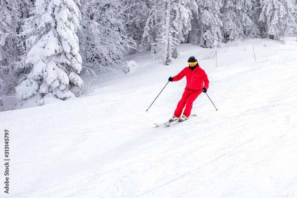 Man skiing in mountain resort during winter vacation