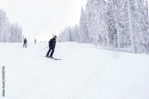 Man skiing downhill in mountain resort 
