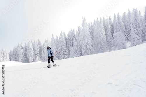 Young woman skiing in mountain resort during winter vacation