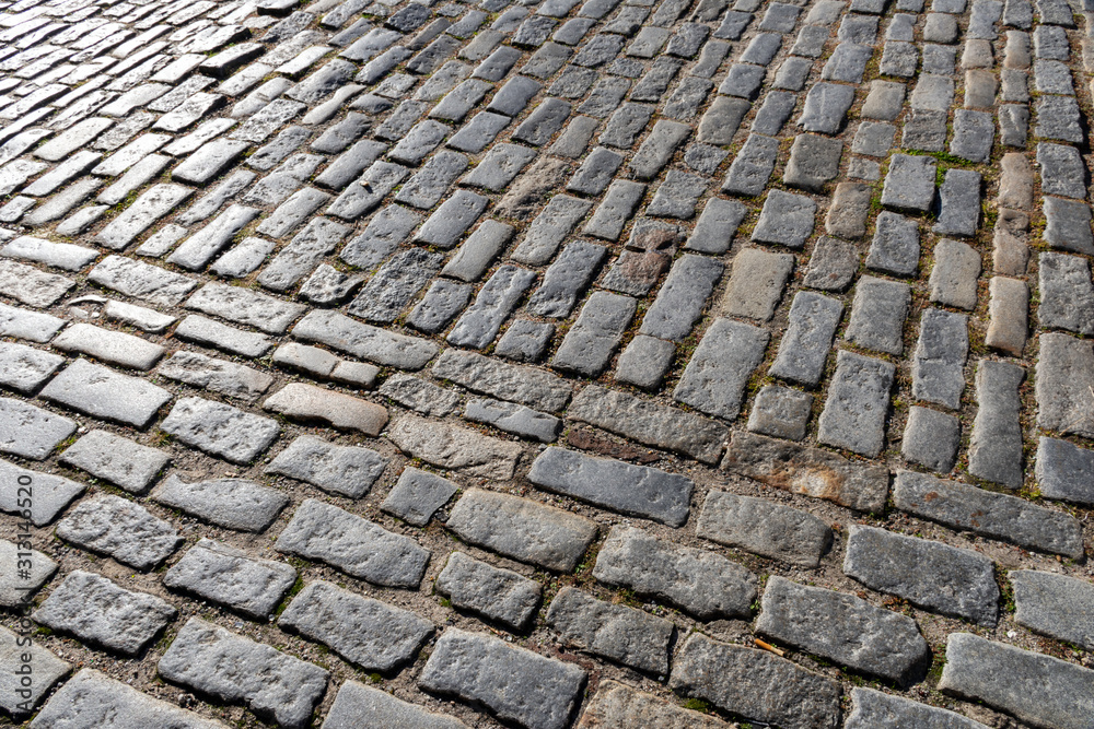 Close up detail showing granite setts or cobblestone, a hardscape materials used in the construction of roads, sidewalks and driveways in the historic district of Charleston, South Carolina.  