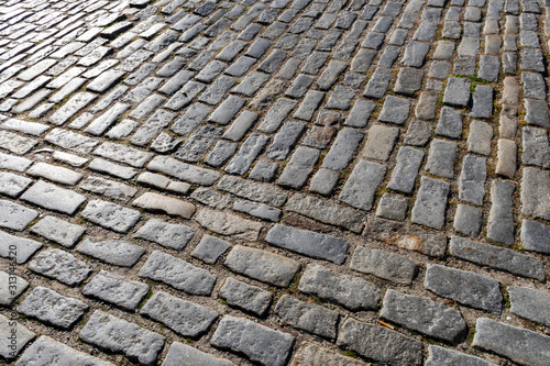 Close up detail showing granite setts or cobblestone, a hardscape materials used in the construction of roads, sidewalks and driveways in the historic district of Charleston, South Carolina. 