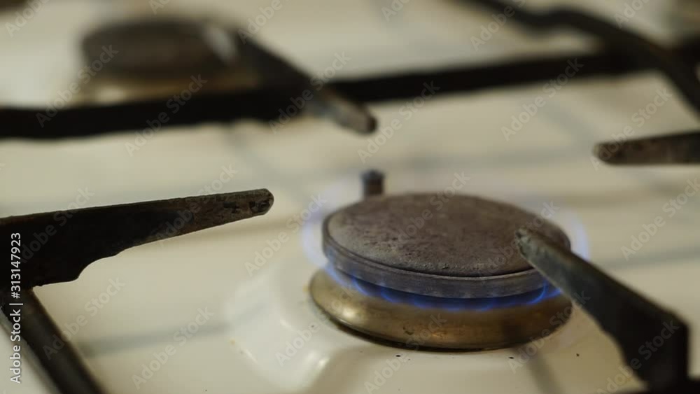 Gas burning in a household stove. Blue flames from burning gas. Gas burns with different intensities, more intensely, less intensely. The intensity of combustion varies. Gas burning in a household stove. Blue flames from burning gas. Gas burns with different intensities, more intensely, less intensely. The intensity of combustion varies.