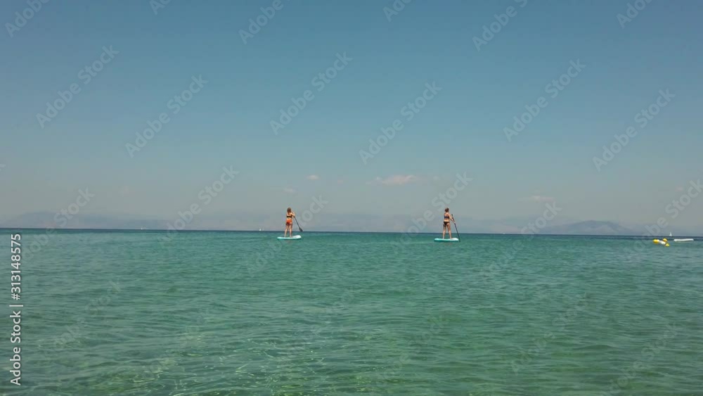 Two Young Teenage girls on Stand Up Paddle SUP board Two Young Teenage girls on Stand Up Paddle SUP board
