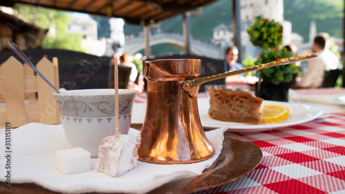 Traditional Turkish coffee and turkish delight. View of Mostar Old bridge in the background, Bosnia and Herzegovina. 