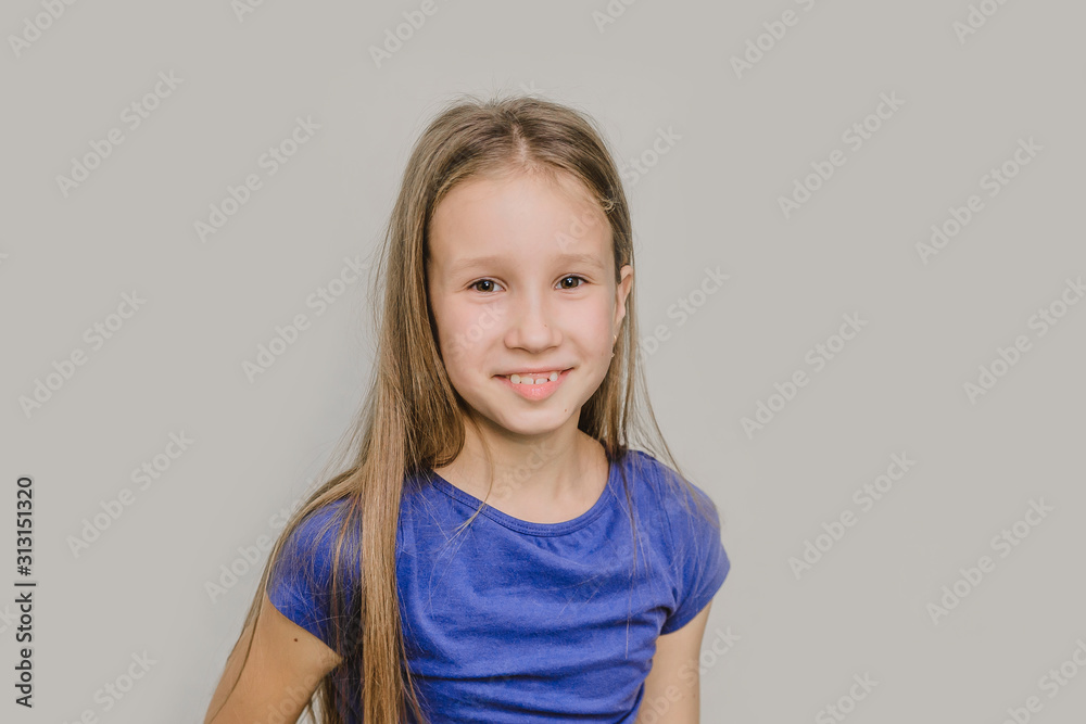 Cute little smiling girl on a white background. portrait of a happy child in a blue t-shirt Cute little smiling girl on a white background. portrait of a happy child in a blue t-shirt