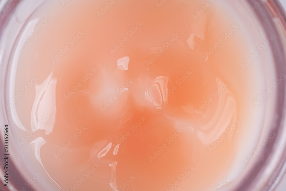 Texture of liquid cream in a pink jar. Cosmetic background. Macro. Texture of liquid cream in a pink jar. Cosmetic background. Macro.