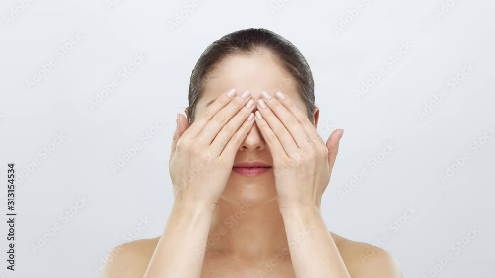 Studio portrait of young, beautiful and natural blond woman applying skin care cream. Face lifting, cosmetics and make-up.