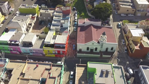 Aerial wide drone shot of Bokaap, Cape Town, South Africa, over Mosque Shafee at Chiapini and Wale Street. Panoramic view of harbor, downtown, Table Mountain and colorful houses of Bo-Kaap sunny day. photo