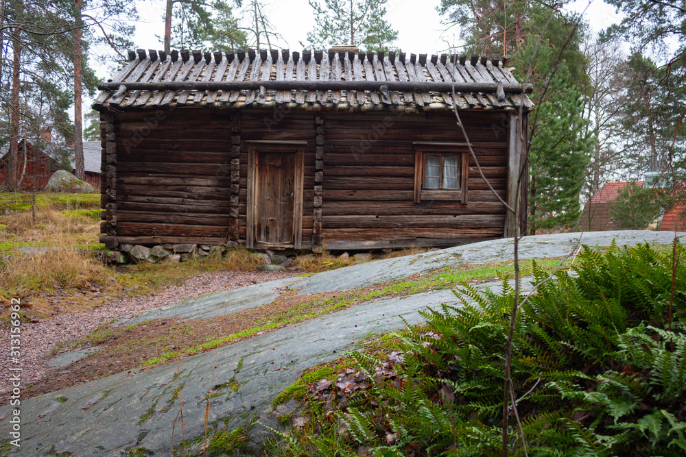 Ancient authentic wooden house of the 17th century in a forest on the island of Seurasaari in Helsinki, Finland, a cloudy day in late autumn. Ancient authentic wooden house of the 17th century in a forest on the island of Seurasaari in Helsinki, Finland, a cloudy day in late autumn.