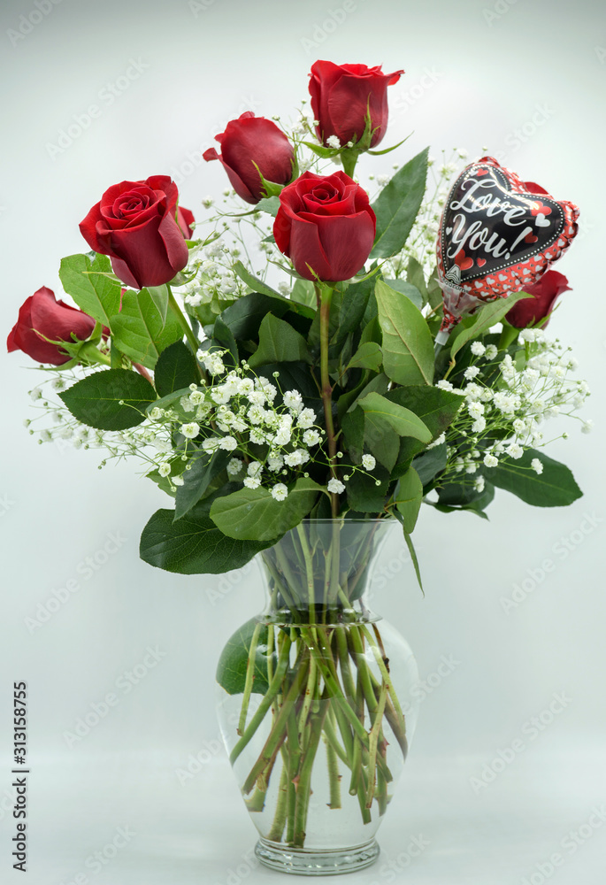 blooming red roses in a clear vase