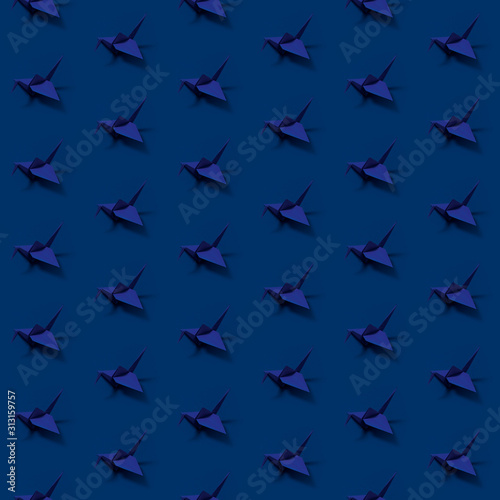 Seamless pattern with origami paper cranes on colored background