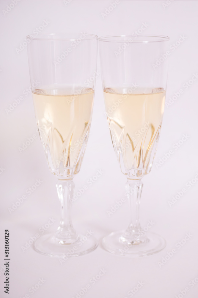 Copas de cristal con vino blanco sobre fondo blanco.