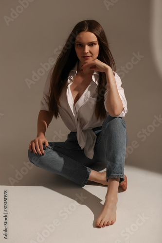  Young girl posing for the camera. Beautiful girl in a white shirt
