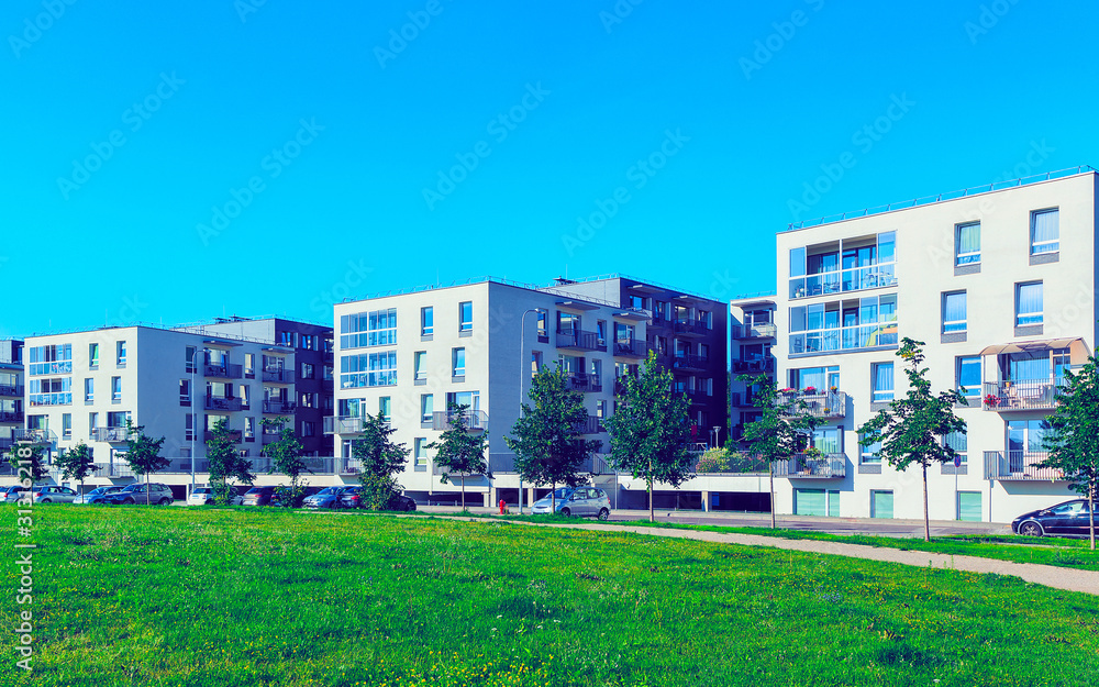Apartment in residential building exterior. Housing structure at blue modern house of Europe. Rental home in city district on summer. Wall and glass high architecture for business property investment.